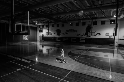 灰度的照片的男孩拿着球站在篮球场
